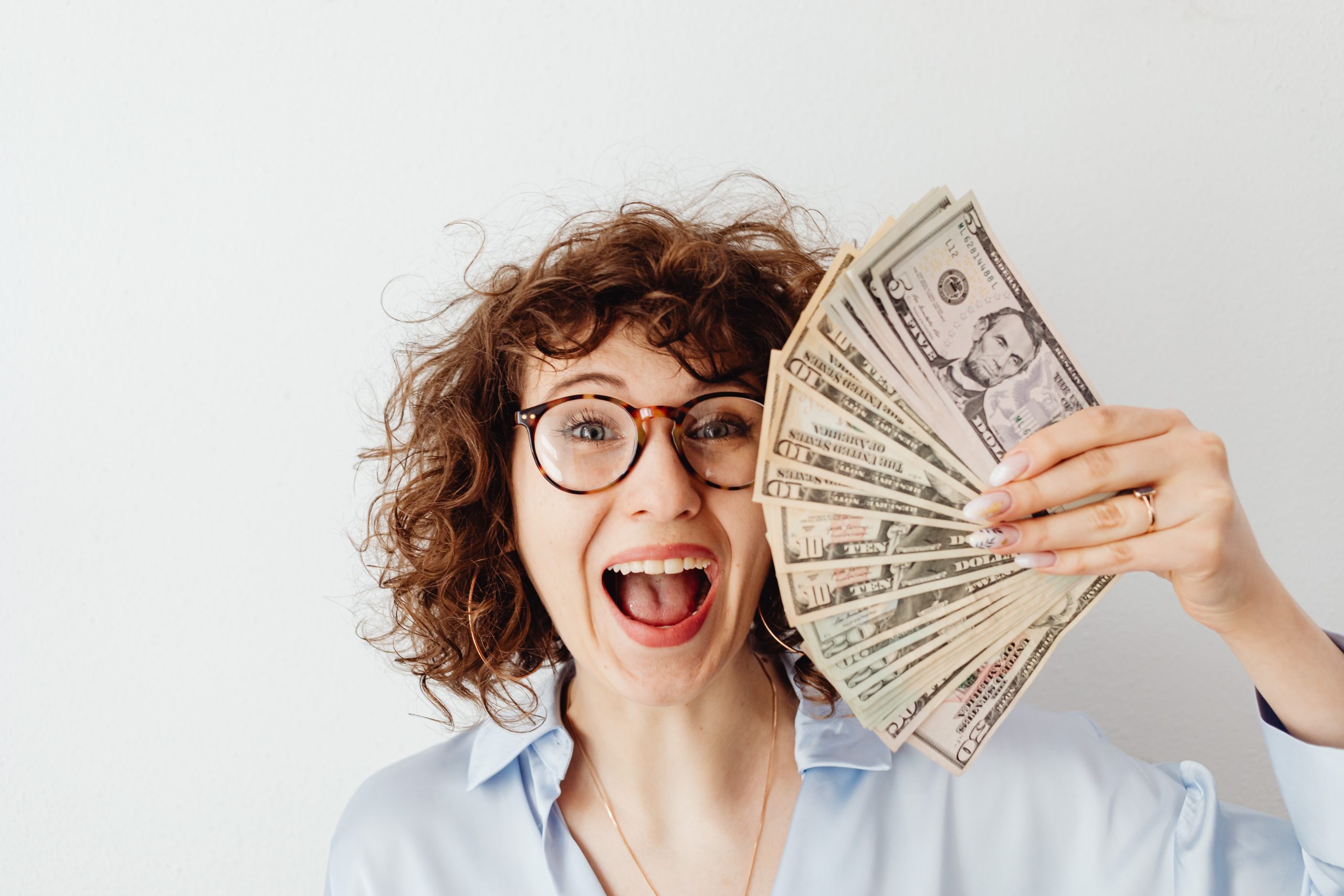 A person smiling while holding banknotes