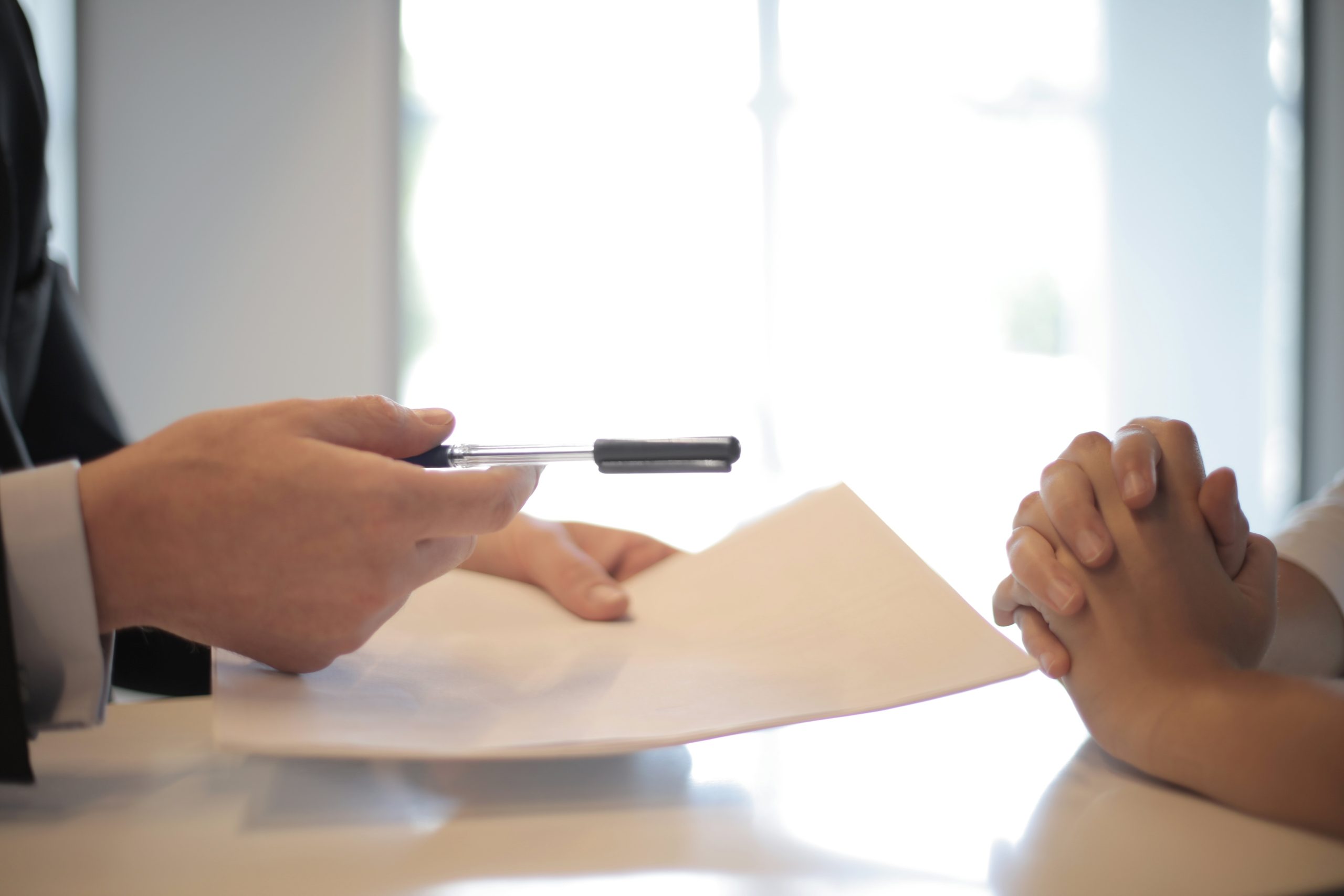 A lender handing a borrower a loan application